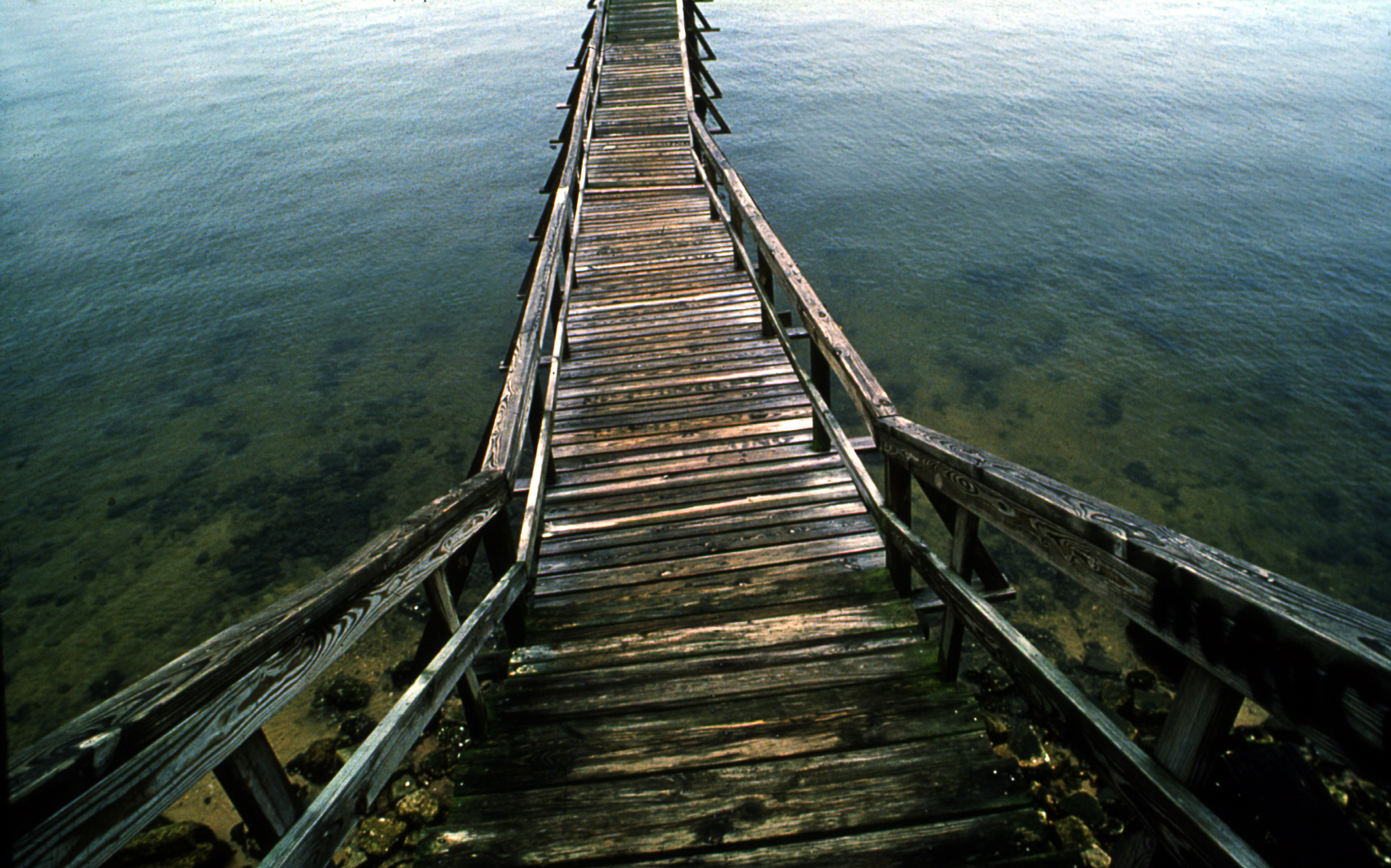 Weathered wooden pier extending into coastal water in Bay St. Louis, Mississippi, fine art photograph